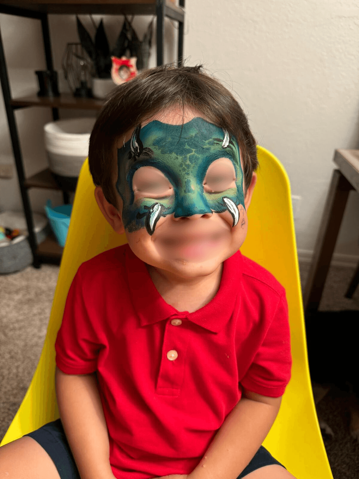 Dragon mask face paint with claws on a boy at a party